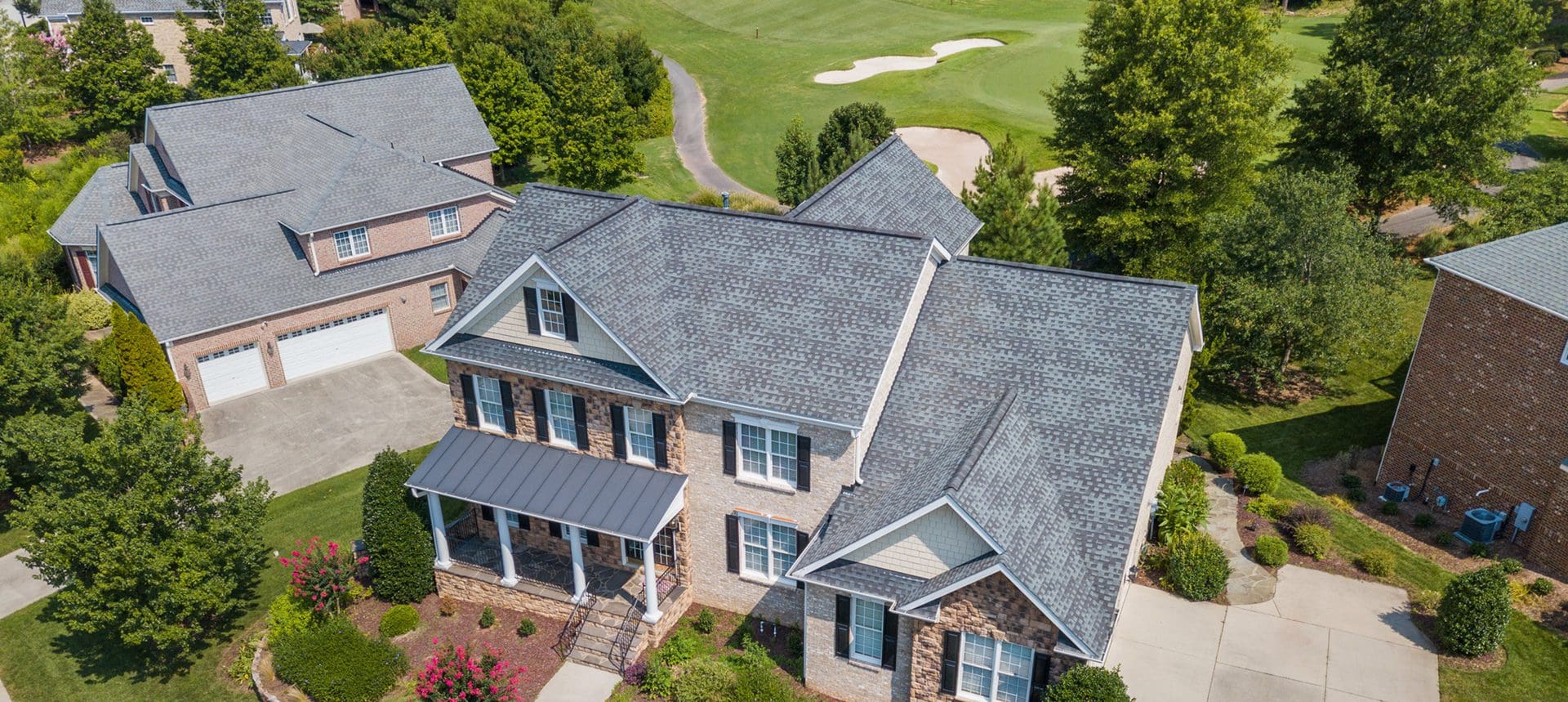 A large house with a golf course in the background.